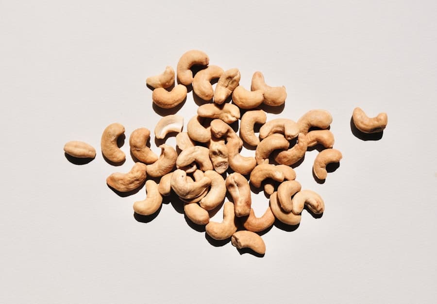 A scattered handful of raw cashew nuts on a plain white surface