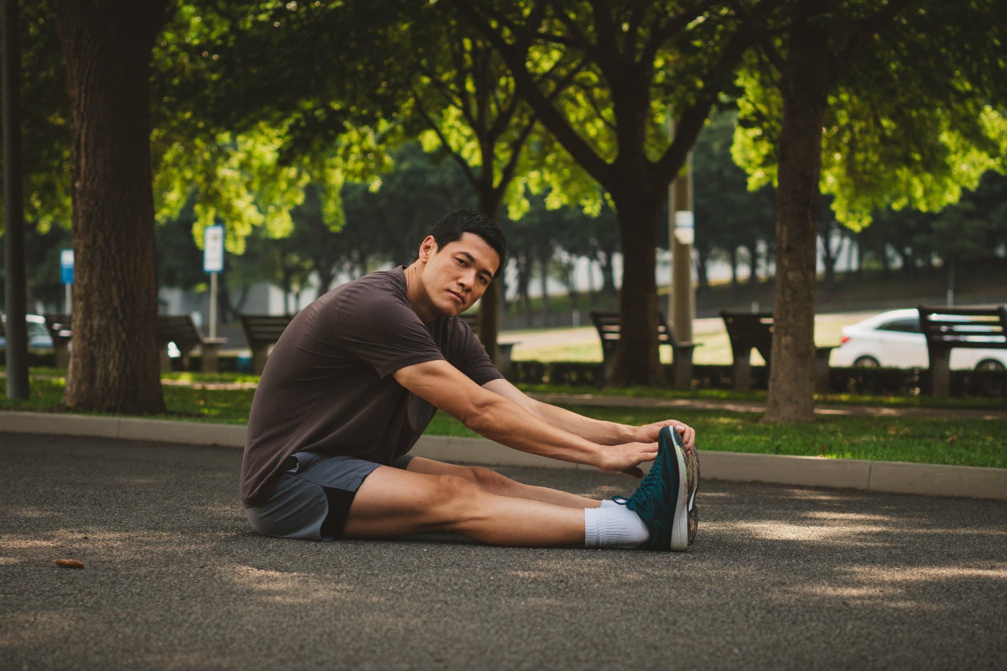 A man stretching after a morning run in a city park