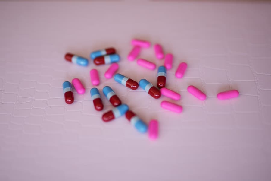 Red-and-blue and pink medicine capsules scattered across a pale pink surface