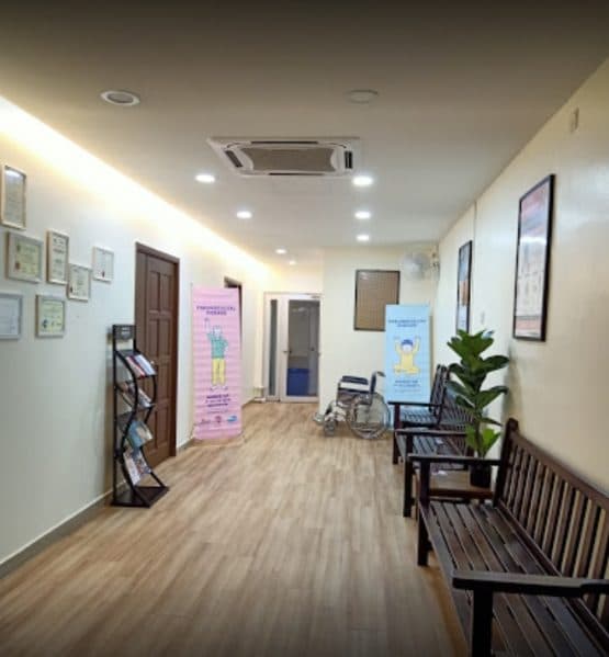 Chye Clinic 的候诊走廊,摆放着木制长椅、单张架与健康海报。